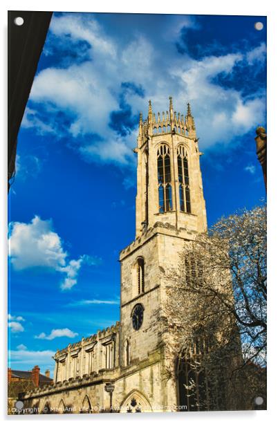 Gothic church tower against a vibrant blue sky with fluffy clouds, showcasing intricate architectural details and a blooming tree at the corner in York, North Yorkshire, England. Acrylic by Man And Life
