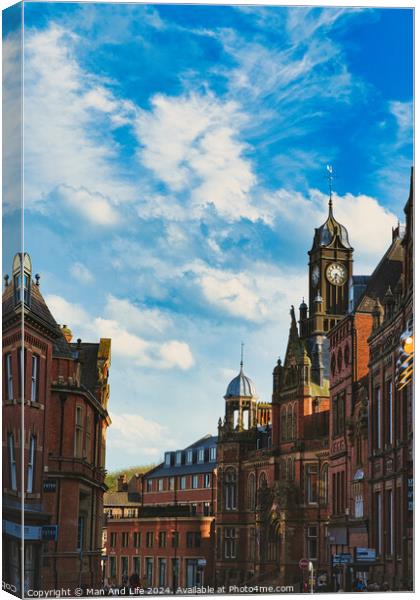 Vintage European architecture with a prominent clock tower under a vibrant blue sky with wispy clouds, capturing the essence of historic urban charm in York, North Yorkshire, England. Canvas Print by Man And Life