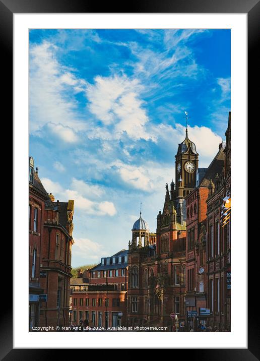 Vintage European architecture with a prominent clock tower under a vibrant blue sky with wispy clouds, capturing the essence of historic urban charm in York, North Yorkshire, England. Framed Mounted Print by Man And Life