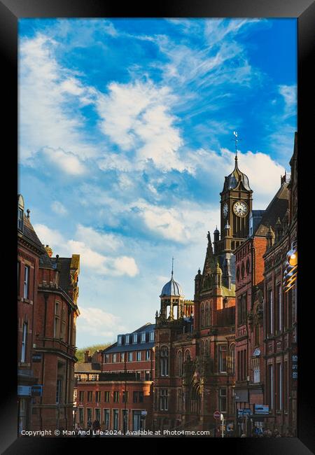 Vintage European architecture with a prominent clock tower under a vibrant blue sky with wispy clouds, capturing the essence of historic urban charm in York, North Yorkshire, England. Framed Print by Man And Life