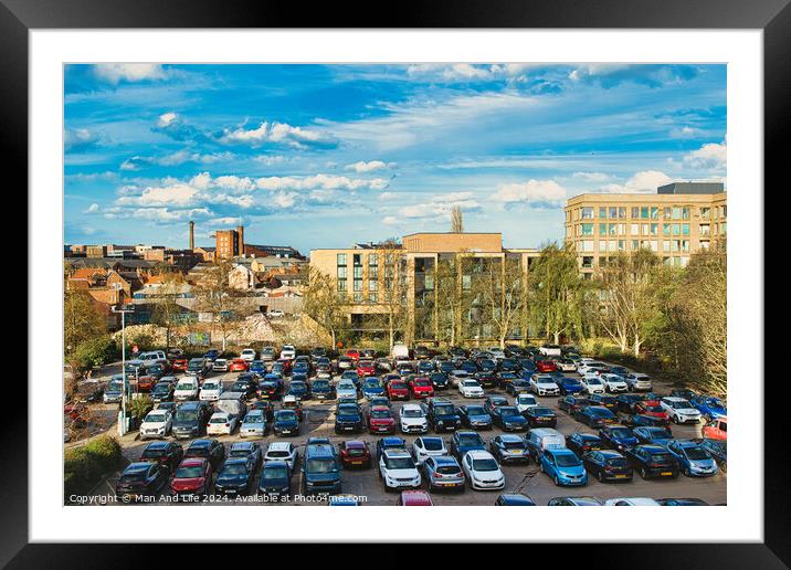Urban parking lot filled with cars on a sunny day, with city buildings in the background and a clear blue sky overhead in York, North Yorkshire, England. Framed Mounted Print by Man And Life
