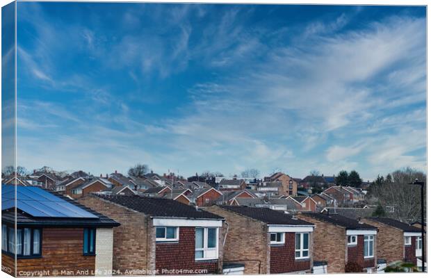 Suburban skyline with rows of houses and solar panels on a roof under a blue sky with wispy clouds in Harrogate, North Yorkshire. Canvas Print by Man And Life