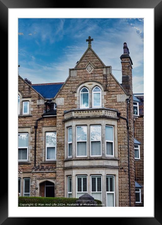 Victorian-style stone building with a gabled roof and bay windows under a blue sky with clouds, showcasing classic architectural details and craftsmanship in Harrogate, North Yorkshire. Framed Mounted Print by Man And Life