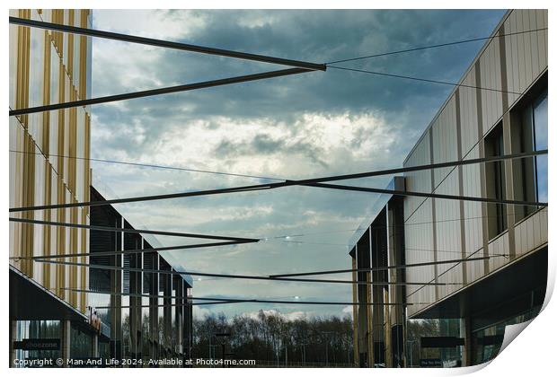 Modern architecture with geometric metal structures against a dramatic cloudy sky, showcasing contemporary urban design and open spaces. Print by Man And Life