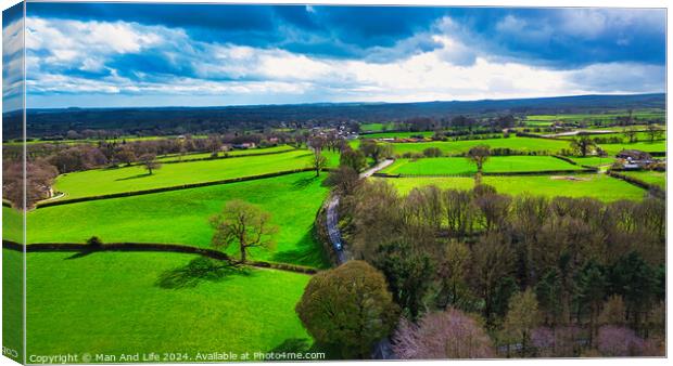 Aerial view of lush green countryside with patchwork fields under a partly cloudy sky. Canvas Print by Man And Life