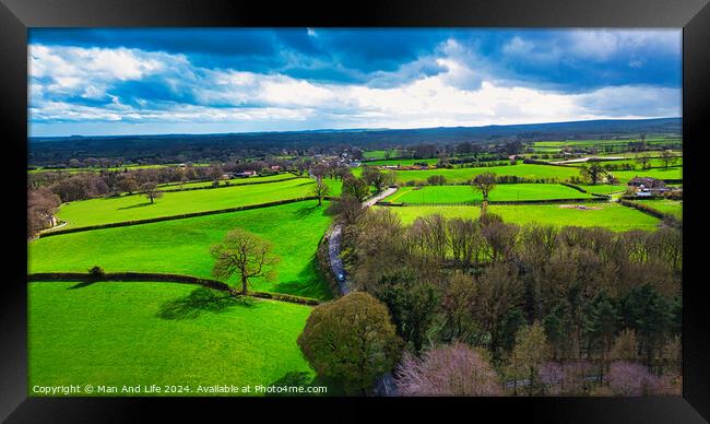 Aerial view of lush green countryside with patchwork fields under a partly cloudy sky. Framed Print by Man And Life