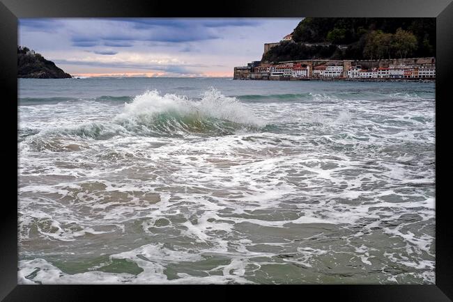 A wave breaks in the bay of San Sebastian, Spain Framed Print by Lensw0rld 