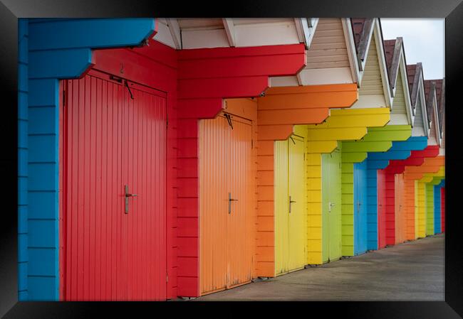 Colourful beach huts (de-focused near and far)  in a row on Scarborough North Bay Beach, Yorkshire, England Framed Print by Dave Collins