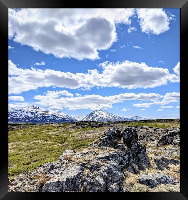 A rocky landscape with clouds and snowy mountains Framed Print by Robert Galvin-Oliphant