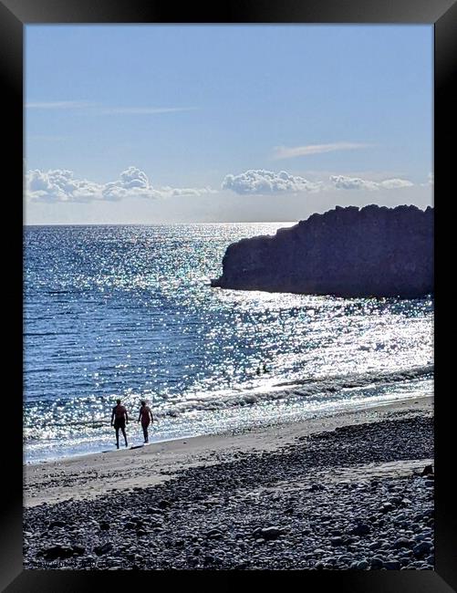 A couple walking on a black beach Framed Print by Robert Galvin-Oliphant