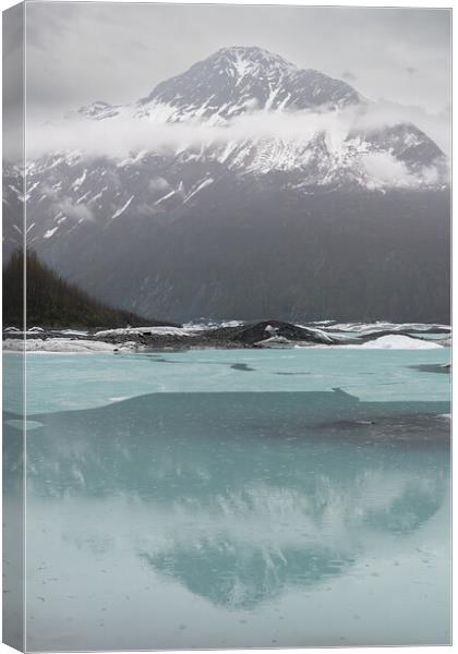 Mist and Snow covered mountains reflected between the ice sheets in Valdez Glacier Lake in the rain, Valdez, Alaska, USA Canvas Print by Dave Collins