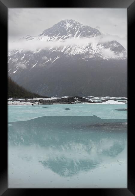 Mist and Snow covered mountains reflected between the ice sheets in Valdez Glacier Lake in the rain, Valdez, Alaska, USA Framed Print by Dave Collins