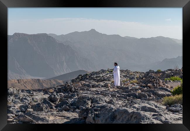 Man in traditional Oman dishdasha in the Harim desert in Musandam, Musandam, Oman Framed Print by Dave Collins