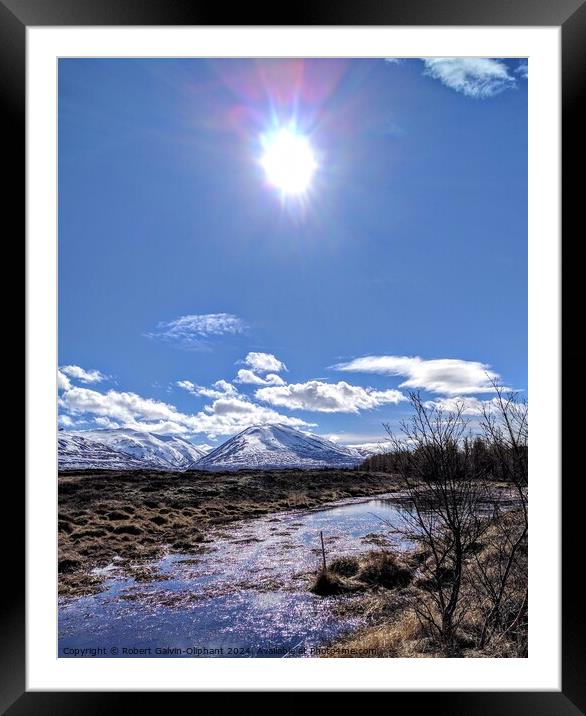 Sun shining on an icy pond and snowy mountains  Framed Mounted Print by Robert Galvin-Oliphant