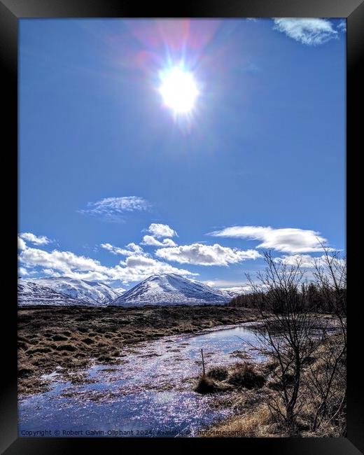 Sun shining on an icy pond and snowy mountains  Framed Print by Robert Galvin-Oliphant