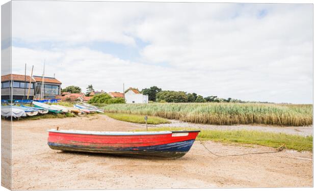 Red and blue boat on the shore at Brancaster Staithe Canvas Print by Jason Wells