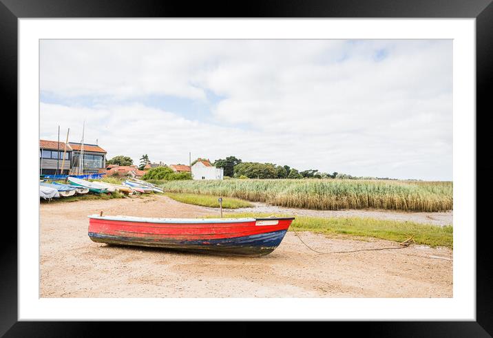 Red and blue boat on the shore at Brancaster Staithe Framed Mounted Print by Jason Wells