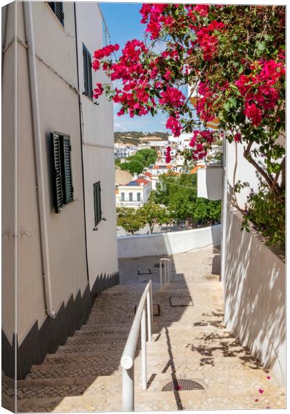 Steep street with Bougainvillea flowers, Albufeira, Portugal Canvas Print by Kevin Hellon