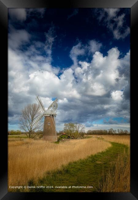 The clouds in the Sky towering over Hardley Mill wind pump Framed Print by Derek Griffin