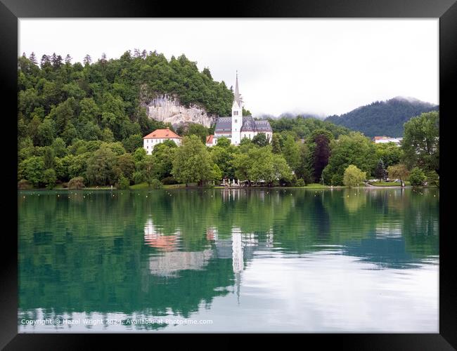 Shows St Martin's Church on the shore of Lake Bled Framed Print by Hazel Wright