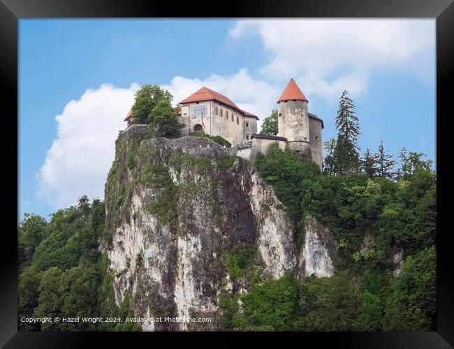 Imposing castle towering over Lake Bled, Slovenia Framed Print by Hazel Wright
