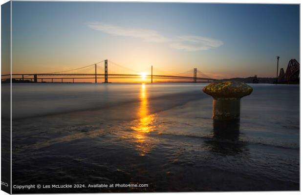 The forth Road Bridges at sunset from the shore at the rail bridge Canvas Print by Les McLuckie