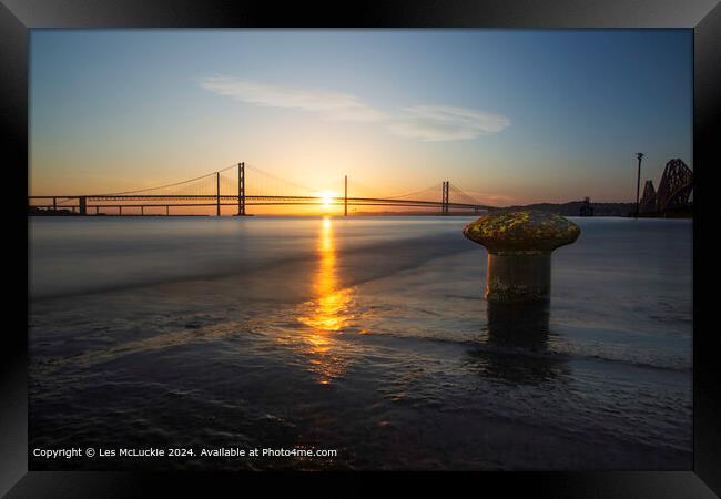 The forth Road Bridges at sunset from the shore at the rail bridge Framed Print by Les McLuckie