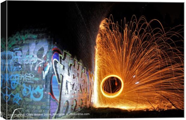 Graffiti illuminated by fire Canvas Print by Chris Brown