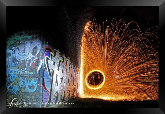 Graffiti illuminated by fire Framed Print by Chris Brown