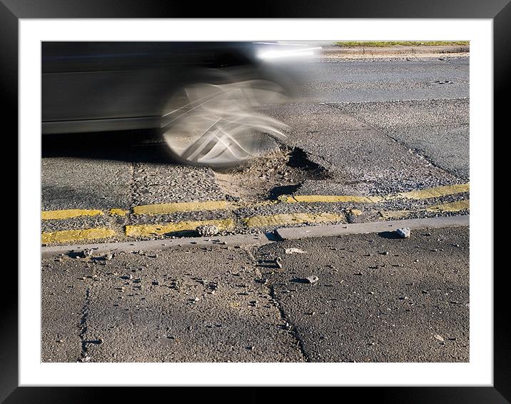Car wheel hitting pothole Framed Mounted Print by Gary Eason