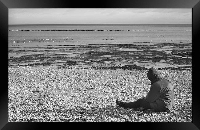 Lone Man Sitting on Pebble Beach Framed Print by Natalie Kinnear
