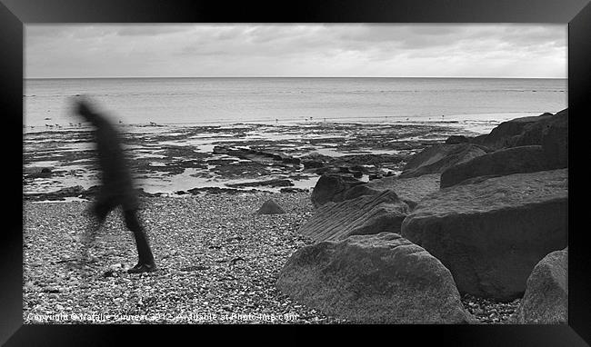 Lone Man Walking Along Pebble Beach Framed Print by Natalie Kinnear