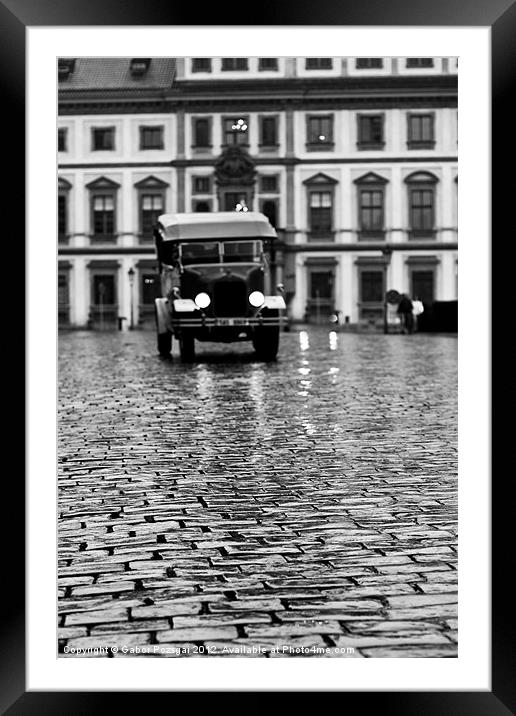 Old car approaching on cobblestone road Framed Mounted Print by Gabor Pozsgai