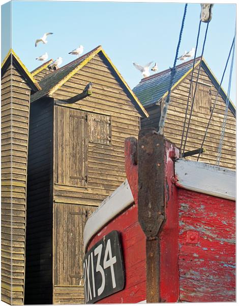 Fishing boat and huts. Canvas Print by Maggie Jones