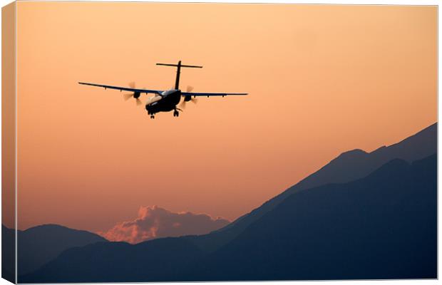 Airplane landing at sunset Canvas Print by Ian Middleton