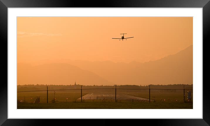 Light airplane landing at sunset Framed Mounted Print by Ian Middleton