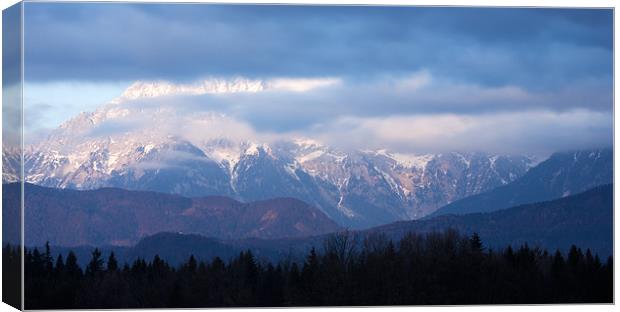 In the shadow of the mountain peak Canvas Print by Ian Middleton