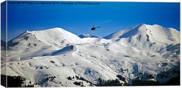 Helicopter over Meribel Mountain Range Canvas Print by Roger Cruickshank
