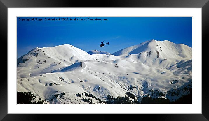 Helicopter over Meribel Mountain Range Framed Mounted Print by Roger Cruickshank