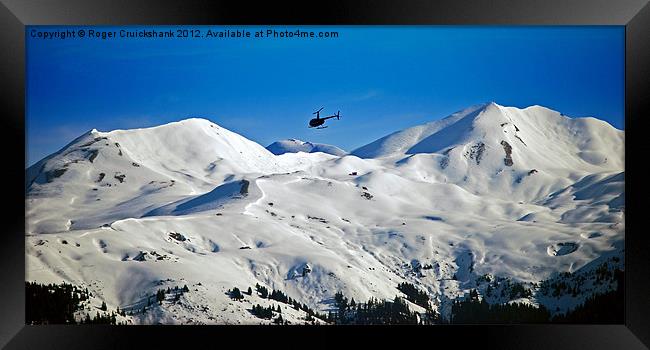 Helicopter over Meribel Mountain Range Framed Print by Roger Cruickshank