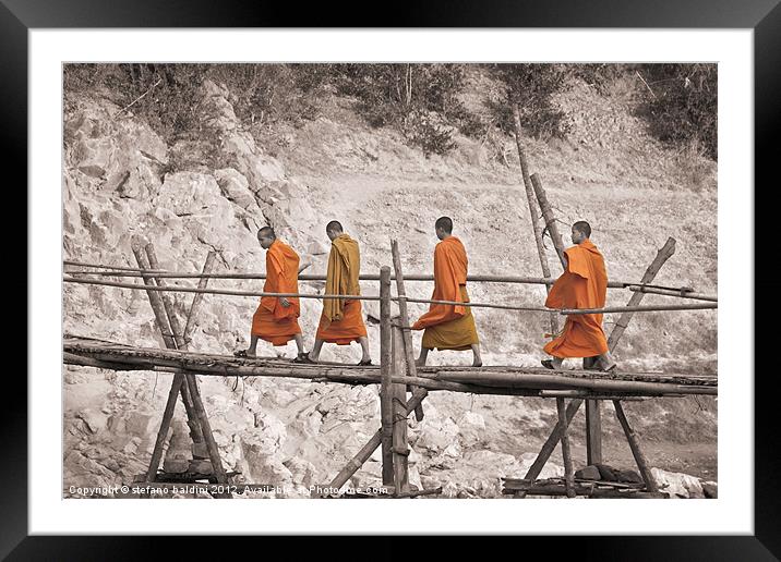 Buddhist monks across a bamboo bridge Framed Mounted Print by stefano baldini