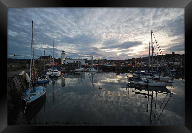 Across the harbour at dusk Framed Print by Stephen Wakefield