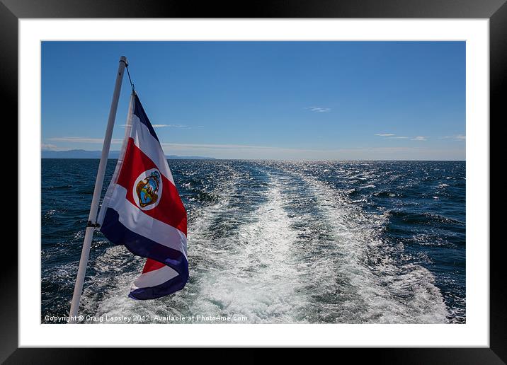 flag flying behind a boat Framed Mounted Print by Craig Lapsley