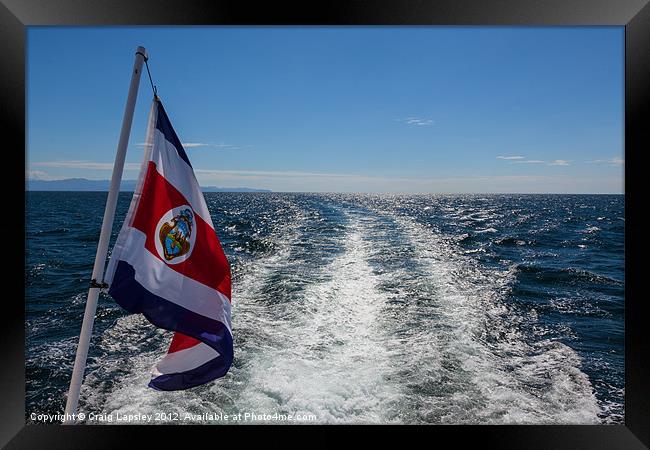 flag flying behind a boat Framed Print by Craig Lapsley