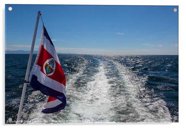 flag flying behind a boat Acrylic by Craig Lapsley