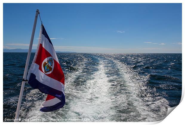 flag flying behind a boat Print by Craig Lapsley