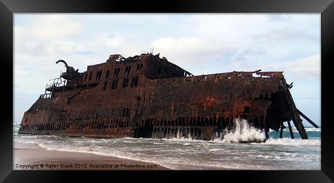 Shipwreck on beach Framed Print by Peter Slack