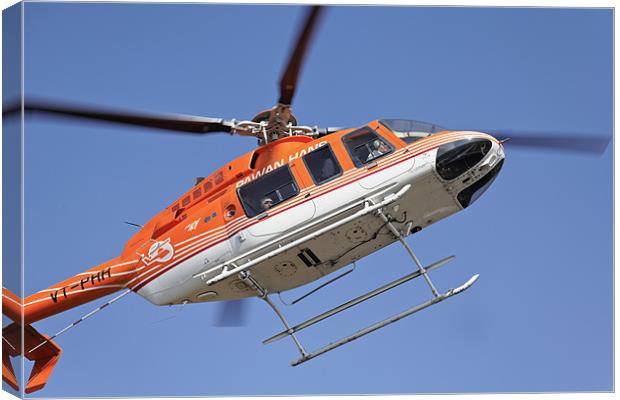 Orange white helicopter hovers over Kashmir Canvas Print by Arfabita  