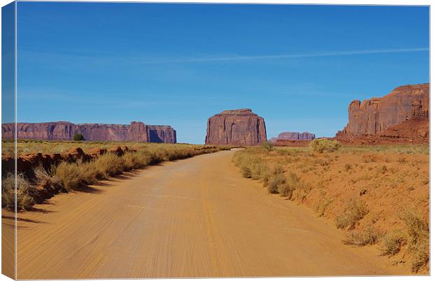 Sand road across Monument Valley, Arizona Canvas Print by Claudio Del Luongo