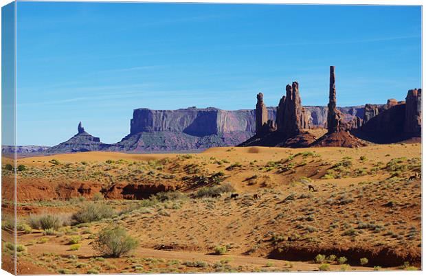 Horses, sand and rock towers, Monument Valley Canvas Print by Claudio Del Luongo